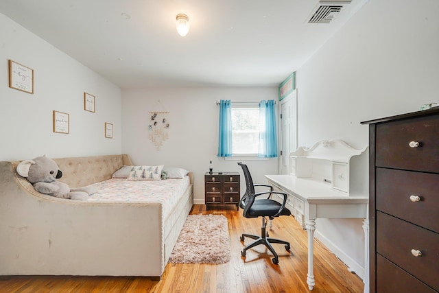 bedroom featuring hardwood / wood-style flooring, baseboards, and visible vents