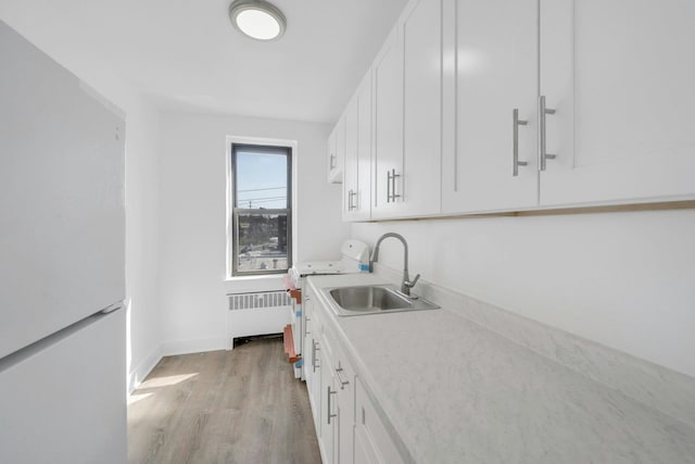 75 Lee Ave Unit 3D, Yonkers, NY 10705 - kitchen with white appliances, a sink, radiator heating unit, and white cabinets