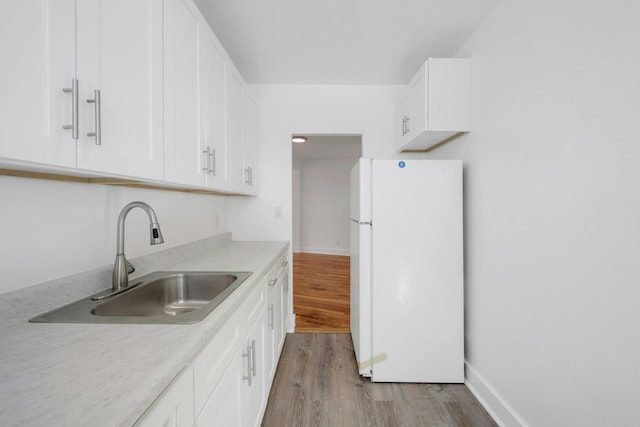 75 Lee Ave Unit 3D, Yonkers, NY 10705 - kitchen with freestanding refrigerator, a sink, light wood-style floors, white cabinets, and light countertops