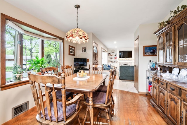 15 Kevin Rd, Commack, NY 11725 - dining area with a fireplace, plenty of natural light, and light wood finished floors