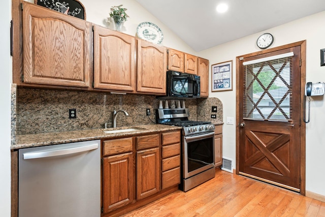15 Kevin Rd, Commack, NY 11725 - kitchen featuring appliances with stainless steel finishes, a sink, backsplash, light wood-type flooring, and lofted ceiling