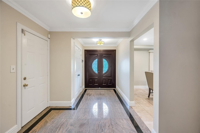 entryway with inlaid floor details, baseboards, ornamental molding, and marble finish flooring
