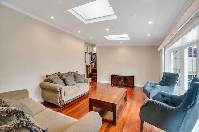 living area with a skylight, ornamental molding, recessed lighting, wood finished floors, and stairs