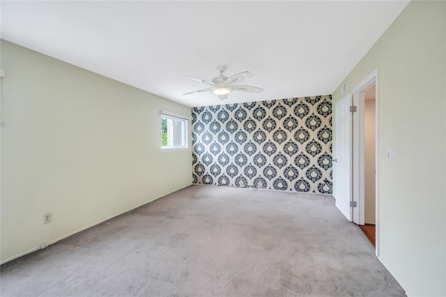carpeted spare room featuring ceiling fan