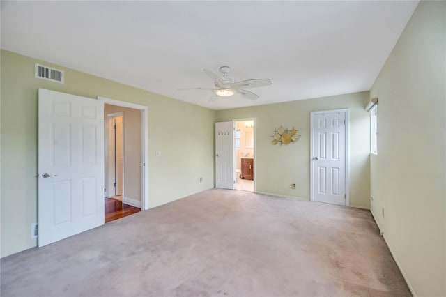 unfurnished bedroom with carpet floors, ensuite bathroom, ceiling fan, a closet, and baseboards