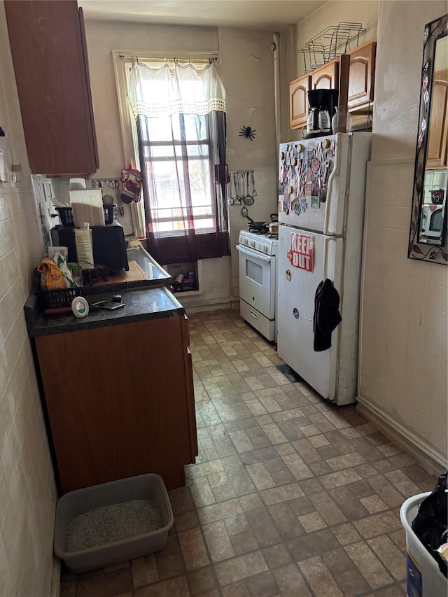 1171 Leland Ave, Bronx, NY 10472 - kitchen with white appliances, tile walls, dark countertops, and brick patterned flooring