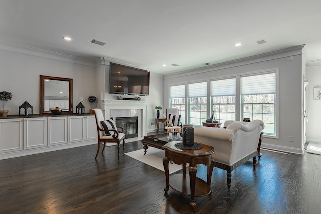 living area with crown molding, visible vents, dark wood-style flooring, recessed lighting, and a tile fireplace