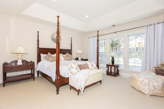 bedroom with visible vents, baseboards, light carpet, a tray ceiling, and recessed lighting