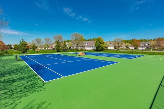 view of tennis court featuring fence and community basketball court