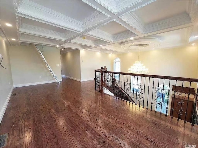 interior space featuring beam ceiling, a chandelier, baseboards, wood finished floors, and coffered ceiling