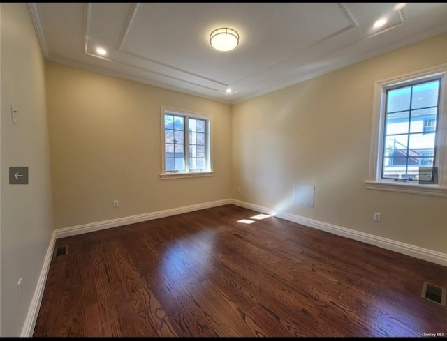 spare room featuring crown molding, baseboards, visible vents, and dark wood finished floors