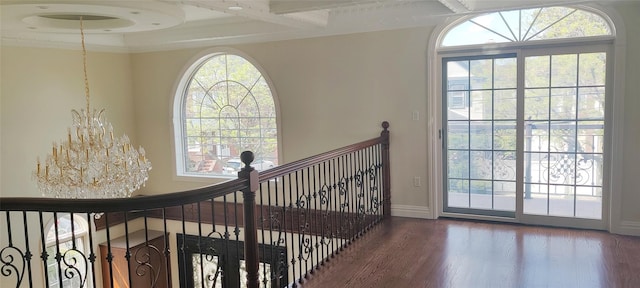 stairs featuring a chandelier, wood finished floors, a wealth of natural light, and beam ceiling
