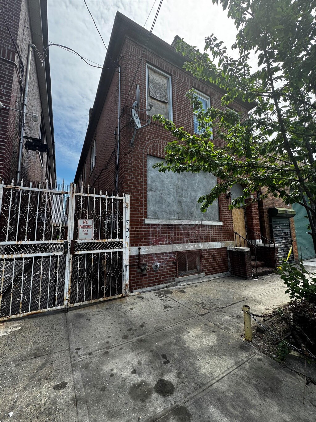 526 Barretto St, Bronx, NY 10474 - view of home's exterior featuring fence, a gate, cooling unit, and brick siding