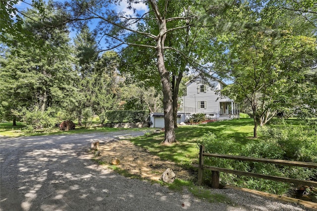 16 Nelson Ln, Garrison, NY 10524 - view of property hidden behind natural elements with fence, aphalt driveway, a front lawn, and a garage