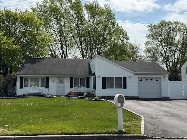 ranch-style house featuring roof with shingles, driveway, a front yard, and a garage