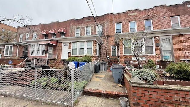 view of property featuring fence private yard and brick siding