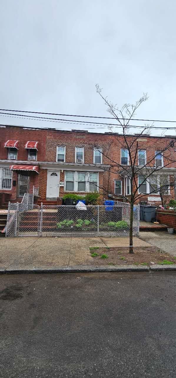 view of front of home featuring a fenced front yard and brick siding