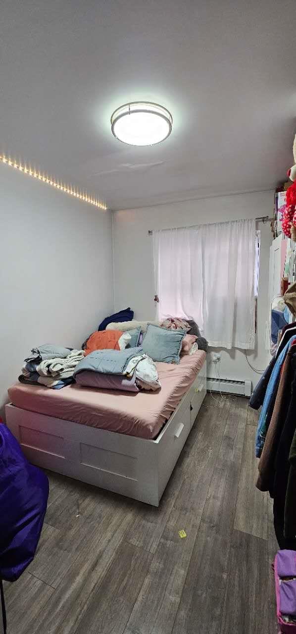 bedroom featuring a baseboard radiator and wood finished floors
