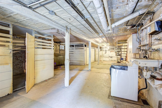 unfinished basement with wood walls and washer and clothes dryer