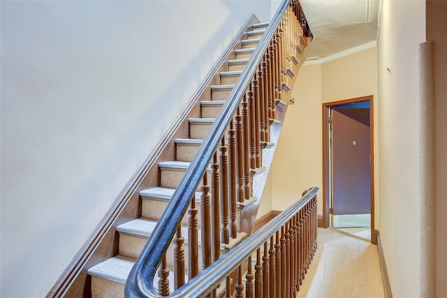 staircase featuring crown molding, baseboards, and speckled floor