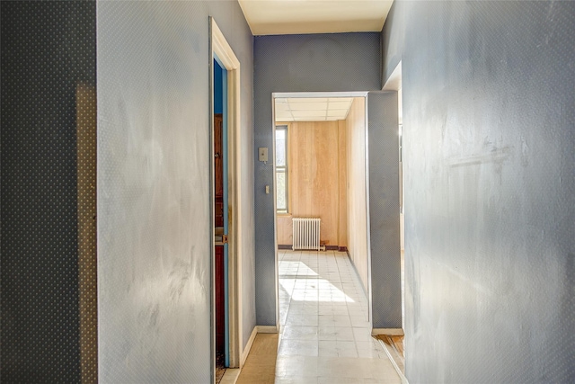 hall featuring light tile patterned floors and radiator