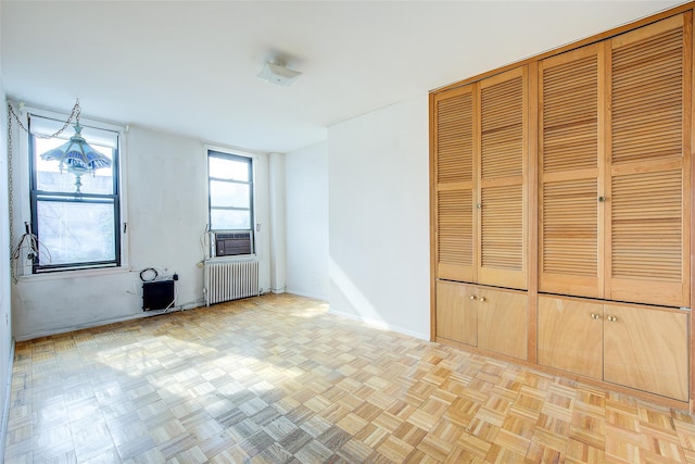 empty room with baseboards, radiator, and cooling unit