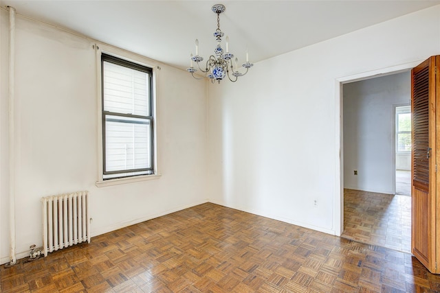 unfurnished room featuring baseboards, a notable chandelier, and radiator heating unit
