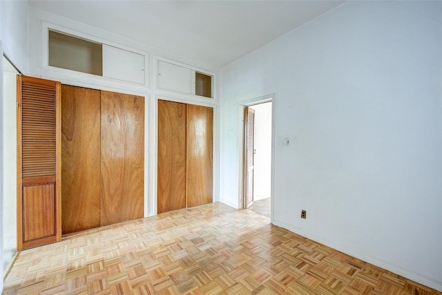 unfurnished bedroom featuring baseboards and two closets