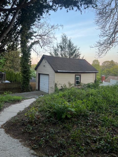 50 Lieper St, Huntington Station, NY 11746 - exterior space featuring fence, an outbuilding, an attached garage, and concrete driveway