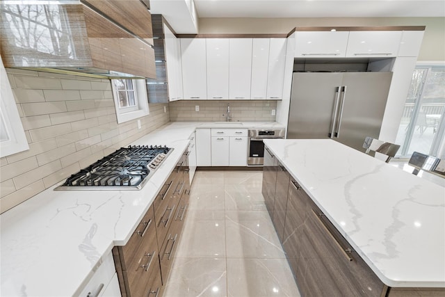 93 Wood Ave, Monticello, NY 12701 - kitchen with wall chimney range hood, a sink, stainless steel appliances, tasteful backsplash, and modern cabinets