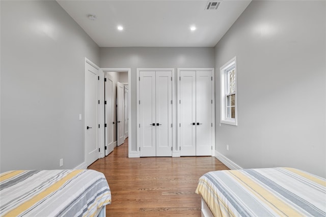 93 Wood Ave, Monticello, NY 12701 - bedroom featuring visible vents, baseboards, two closets, recessed lighting, and light wood-style flooring