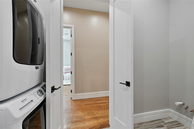 93 Wood Ave, Monticello, NY 12701 - clothes washing area with baseboards, light wood-style flooring, and stacked washer / drying machine