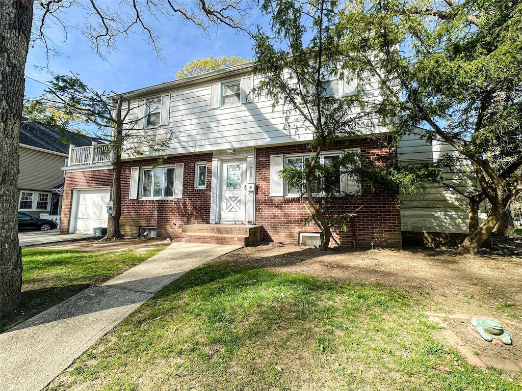 329 E Euclid St, Valley Stream, NY 11580 - view of front of property with brick siding, a garage, a balcony, and a front yard
