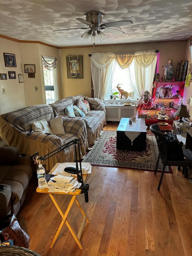living room with light wood-style floors, ornamental molding, ceiling fan, and radiator heating unit