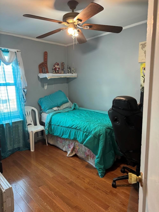 bedroom with crown molding, a ceiling fan, and wood finished floors
