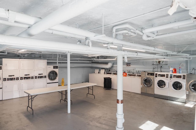 unfinished basement with stacked washer and dryer and washing machine and dryer