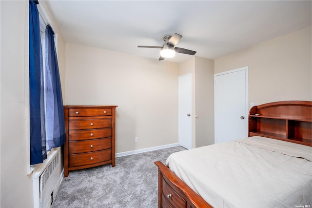 carpeted bedroom featuring radiator heating unit, baseboards, and ceiling fan