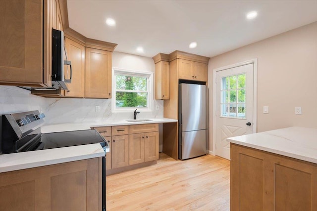 105 Phyllis Dr, Lindenhurst, NY 11757 - kitchen with appliances with stainless steel finishes, a sink, light wood finished floors, tasteful backsplash, and recessed lighting