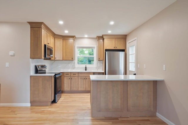 105 Phyllis Dr, Lindenhurst, NY 11757 - kitchen featuring appliances with stainless steel finishes, a sink, light wood-style floors, light countertops, and tasteful backsplash