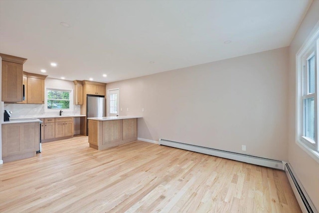 105 Phyllis Dr, Lindenhurst, NY 11757 - kitchen with a peninsula, light countertops, light wood-style floors, and baseboard heating