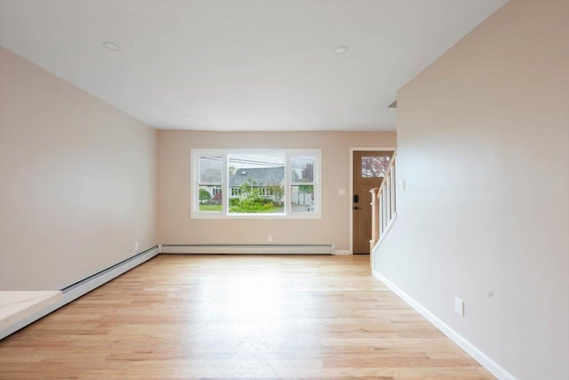 105 Phyllis Dr, Lindenhurst, NY 11757 - spare room featuring stairway, a baseboard radiator, light wood-style flooring, and baseboards