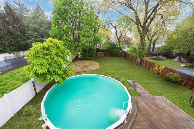 105 Phyllis Dr, Lindenhurst, NY 11757 - view of pool featuring a fenced backyard, a wooden deck, and a lawn