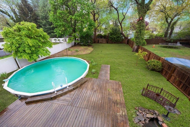 105 Phyllis Dr, Lindenhurst, NY 11757 - view of swimming pool with a fenced backyard, a deck, a trampoline, and a lawn