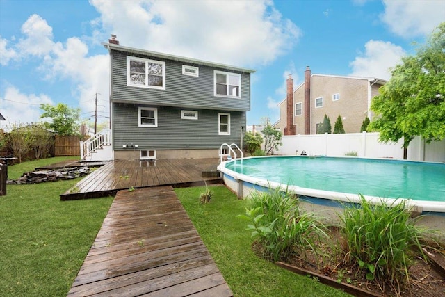 105 Phyllis Dr, Lindenhurst, NY 11757 - rear view of property featuring a deck, a yard, a fenced backyard, a fenced in pool, and a chimney