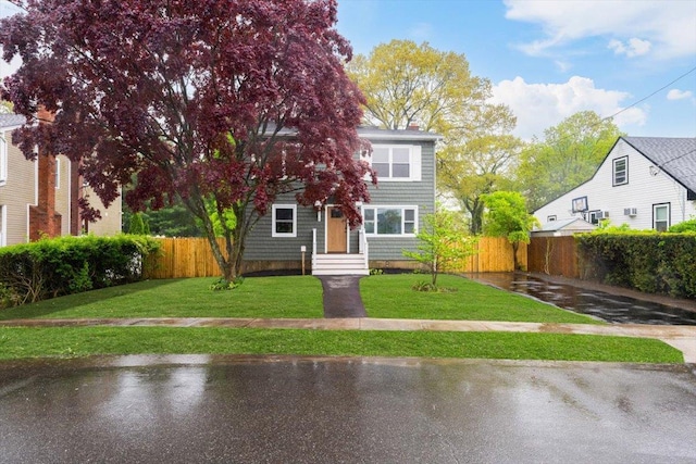 105 Phyllis Dr, Lindenhurst, NY 11757 - view of front of home featuring a chimney, fence, and a front yard