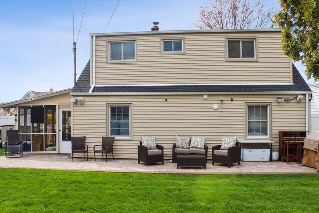 back of property with a patio, roof with shingles, an outdoor hangout area, a sunroom, and a yard