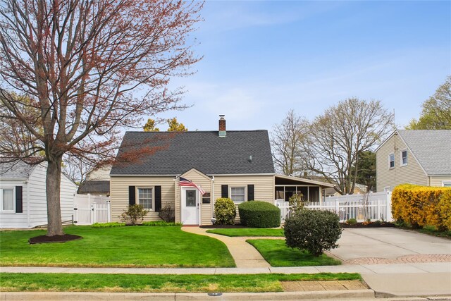 new england style home featuring a shingled roof, a front lawn, fence, and a chimney