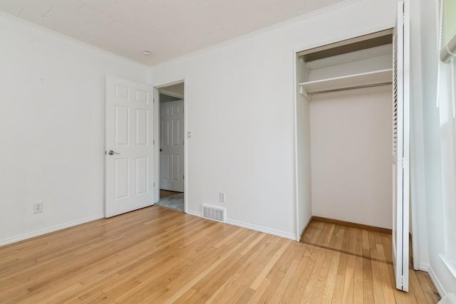 900 Cedar Dr, Southold, NY 11971 - unfurnished bedroom featuring light wood-style floors, crown molding, baseboards, and a closet