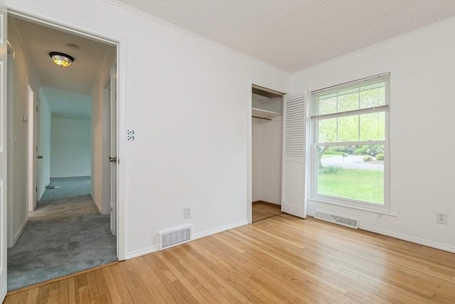 900 Cedar Dr, Southold, NY 11971 - unfurnished bedroom featuring wood-type flooring, crown molding, baseboards, and a closet