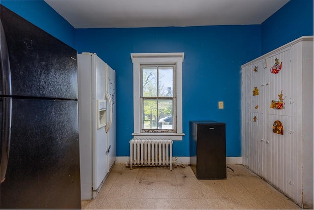 interior space featuring freestanding refrigerator, tile patterned floors, radiator heating unit, and white refrigerator with ice dispenser